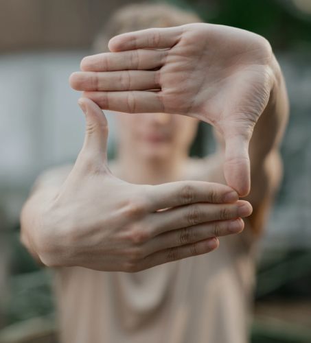 Uomo che con le mani crea una cornice dove inquadra un punto visivo