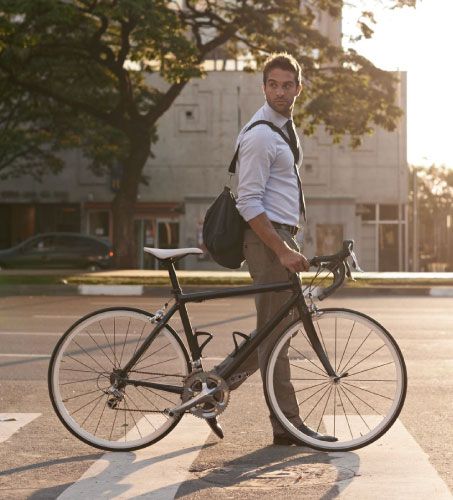 Uomo che cammina portando con con sé una bicicletta