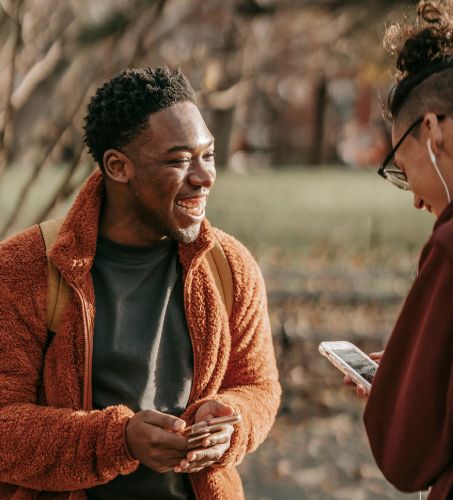 Ragazzi che sorridono guardando le novità sul loro smartphone