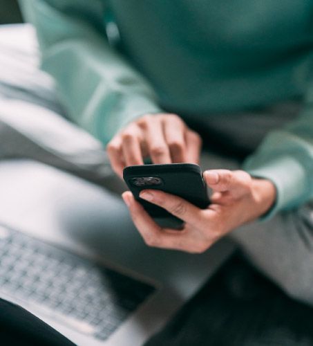 Mani che usano telefono con computer