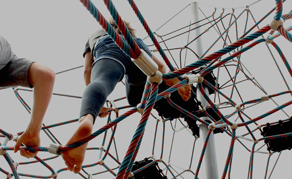 Persone che si arrampicano su una struttura sospesa fatta di corde intrecciate